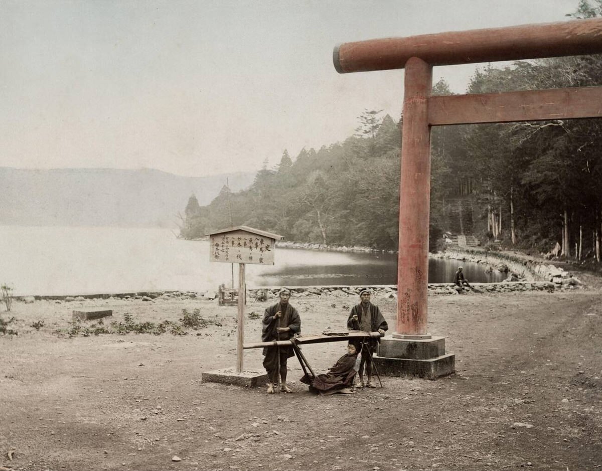 Torii gate and carrying chairs on the shore of Lake Hakone, 1890