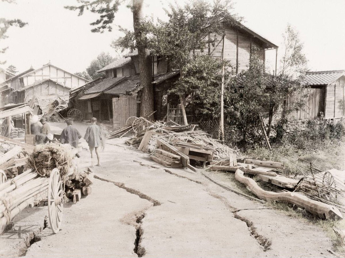 Earthquake damage and cracked ground on a village street, 1890s