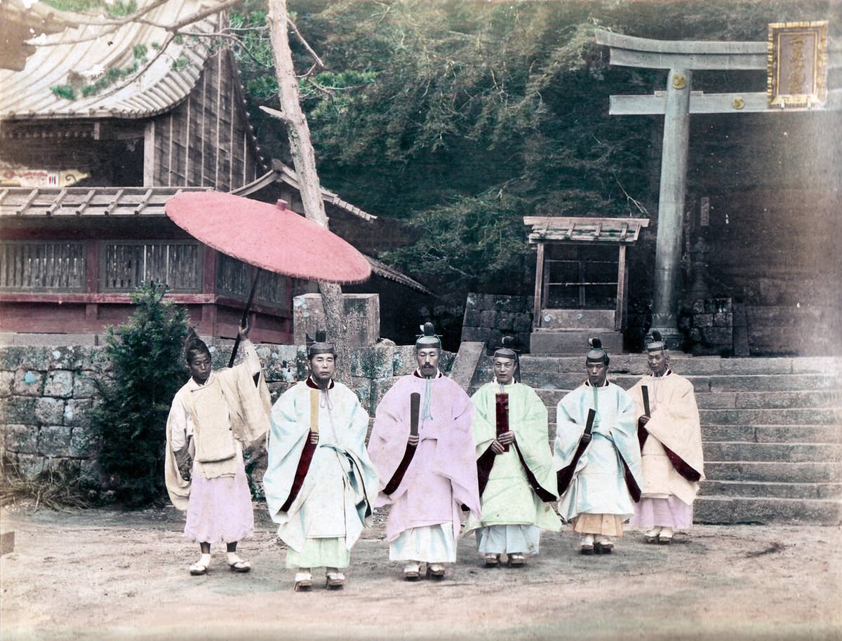 Shinto priests with a large parasol, 1890s