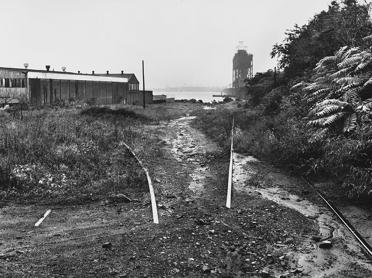 Abandoned railroad tracks and shuttered factories in Bayonne looking across Newark Bay, 1978