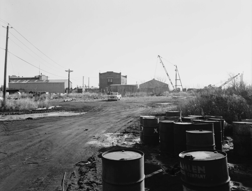 Chemical drums and abandoned buildings at Central Railroad of New Jersey Pier No. 19, 1975