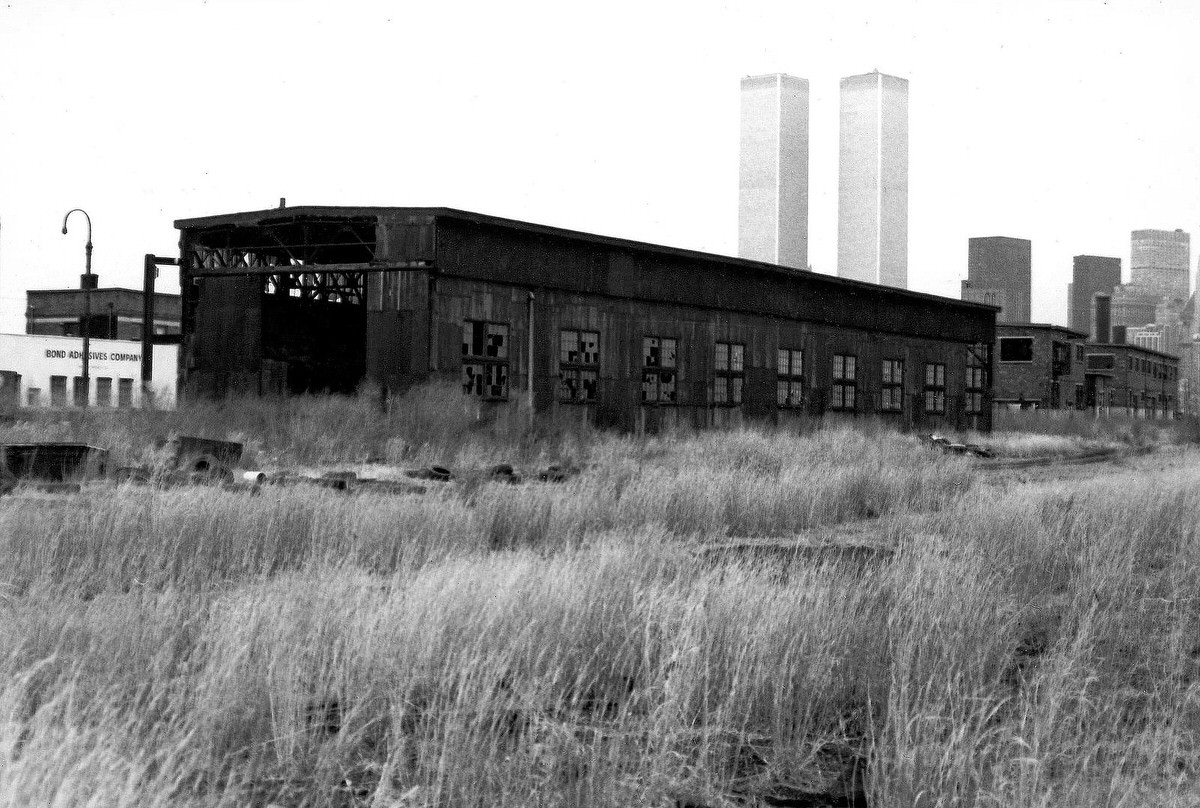Abandoned Central Railroad of New Jersey buildings with the World Trade Center in the background, 1975
