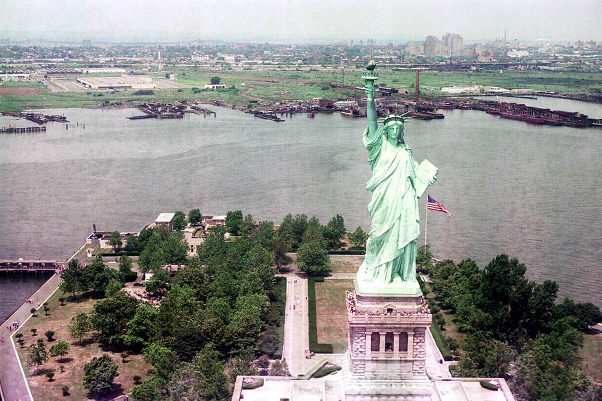 Aerial view of the Statue of Liberty and the abandoned railroad shoreline of Jersey City, 1975