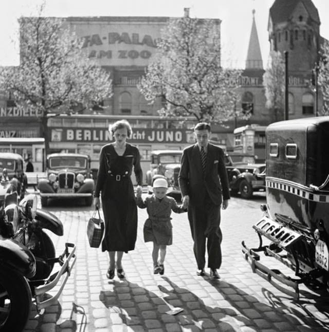German family walking between taxi cabs in front of the Ufa-Palast cinema, Berlin, 1930s