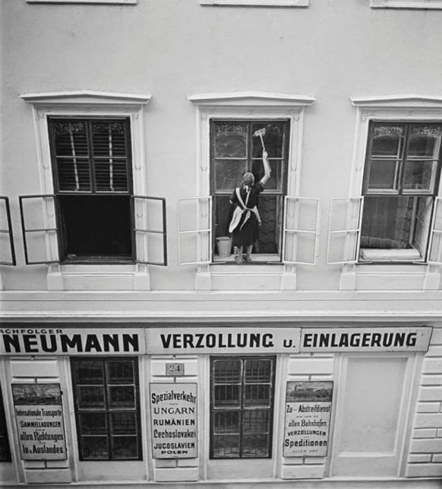 Woman washing windows above Mandtler & Neumann Speditionen, Vienna, 1930s