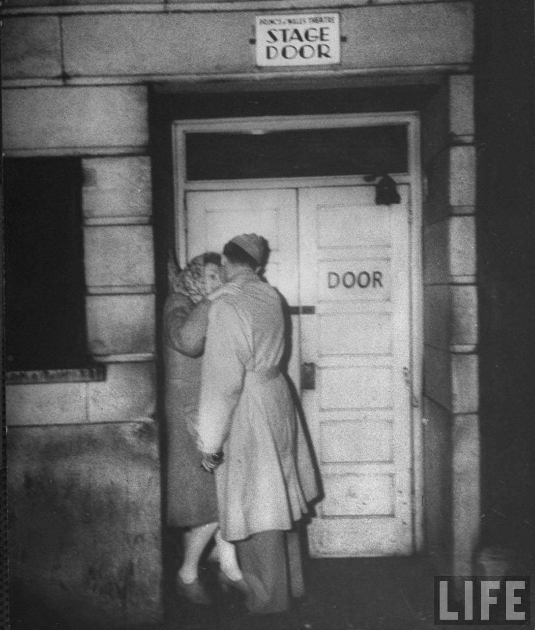 Couple embracing outside the stage door of the Prince of Wales Theatre on lower Wardour Street, 1940s