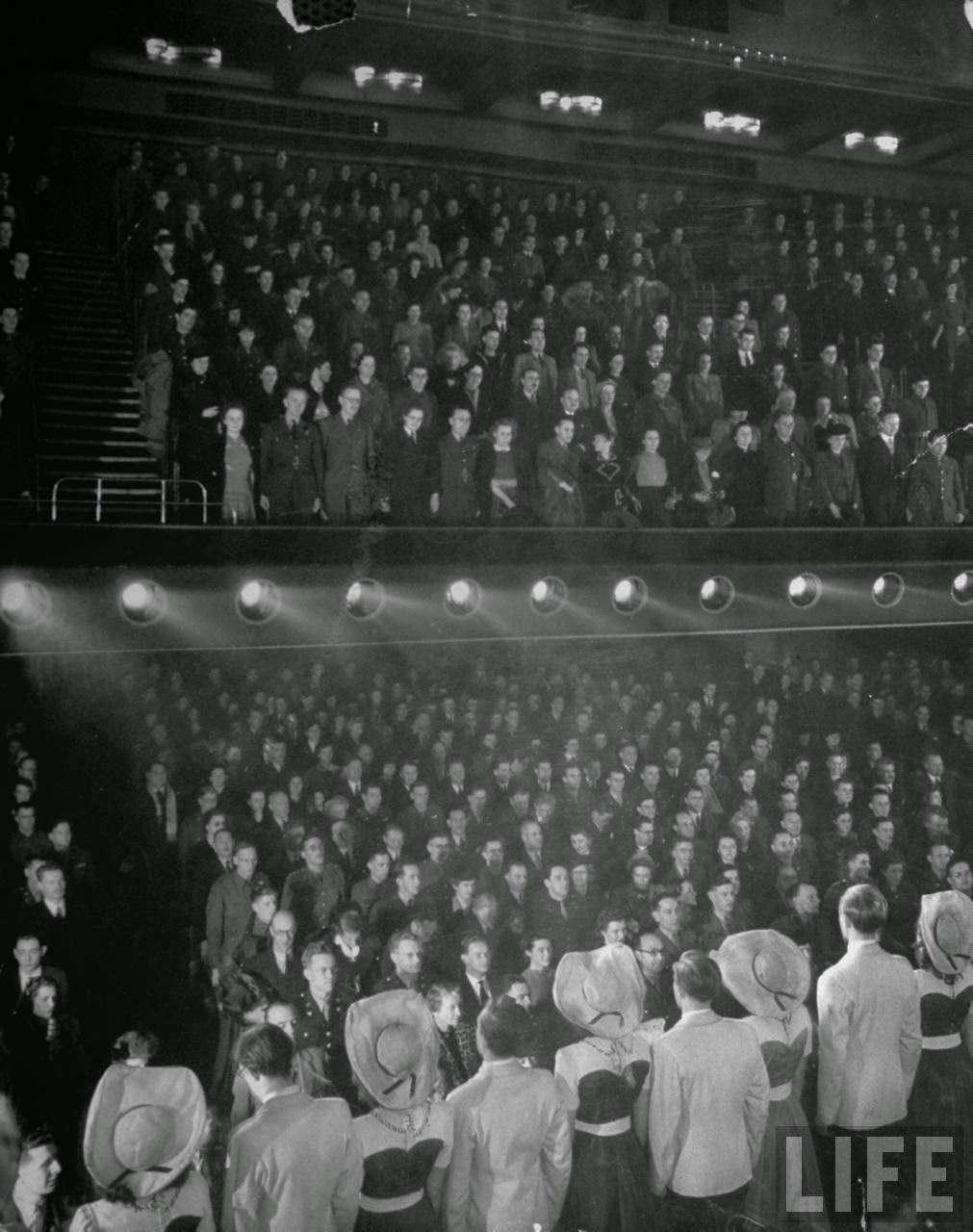 Cast and audience of Strike a New Note at the Prince of Wales singing The King, 1940s