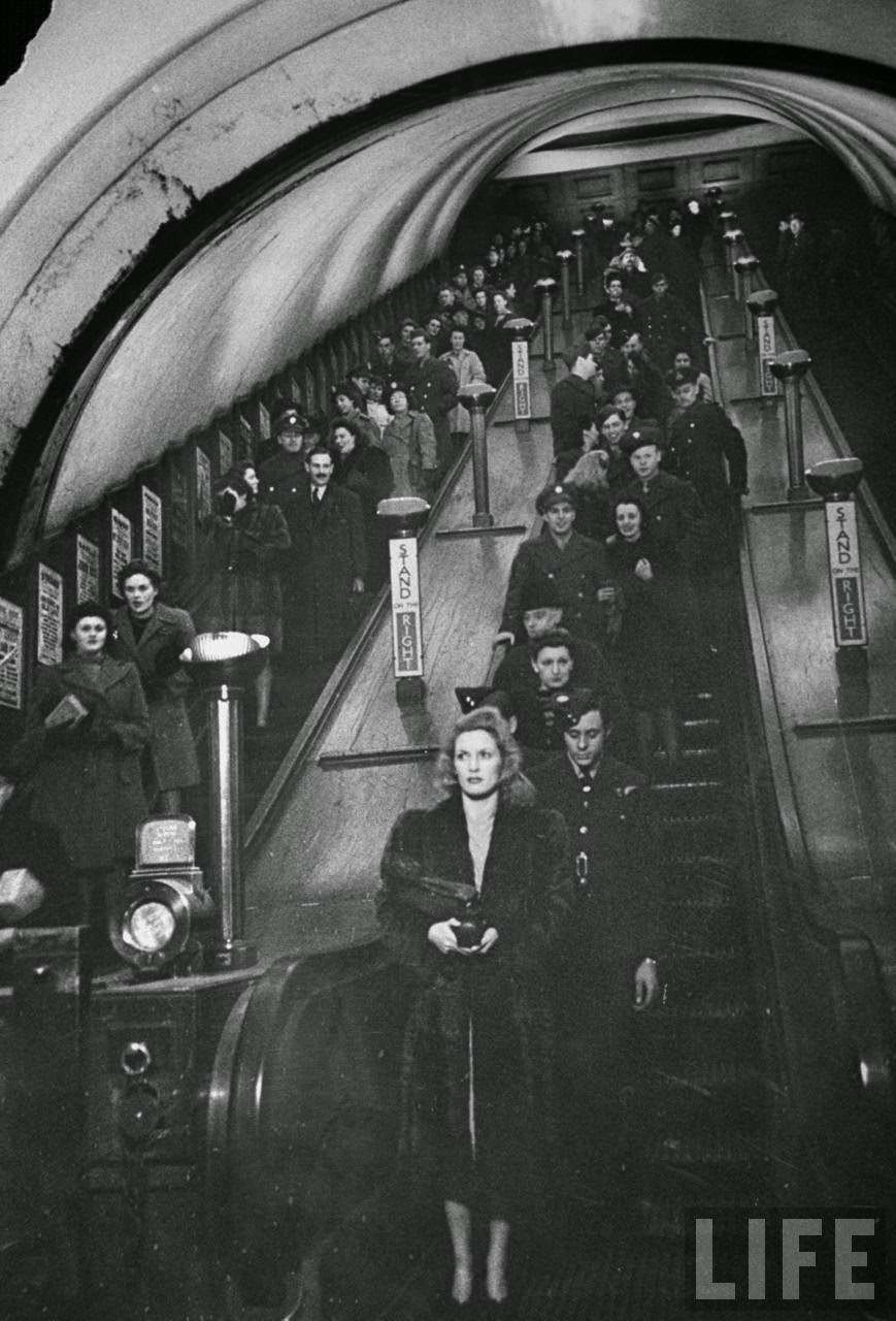 Night-lifers, servicemen, and war workers on escalators at Piccadilly Circus underground station during World War II, 1940s