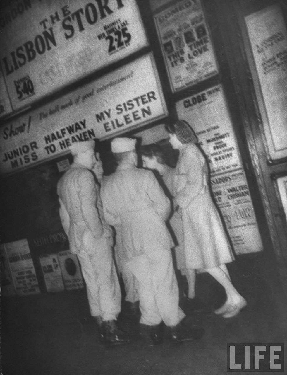 People outside Keith Prowse discussing theater shows, 1940s
