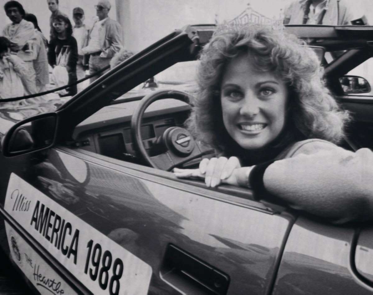 Kaye Lani Rae Rafko driving a Corvette while wearing her crown, 1988