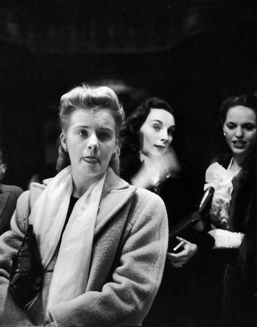 Woman moistening her lips, while others are checking out their own profiles