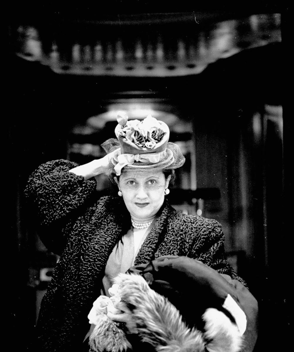 Woman adjusting flowered hat