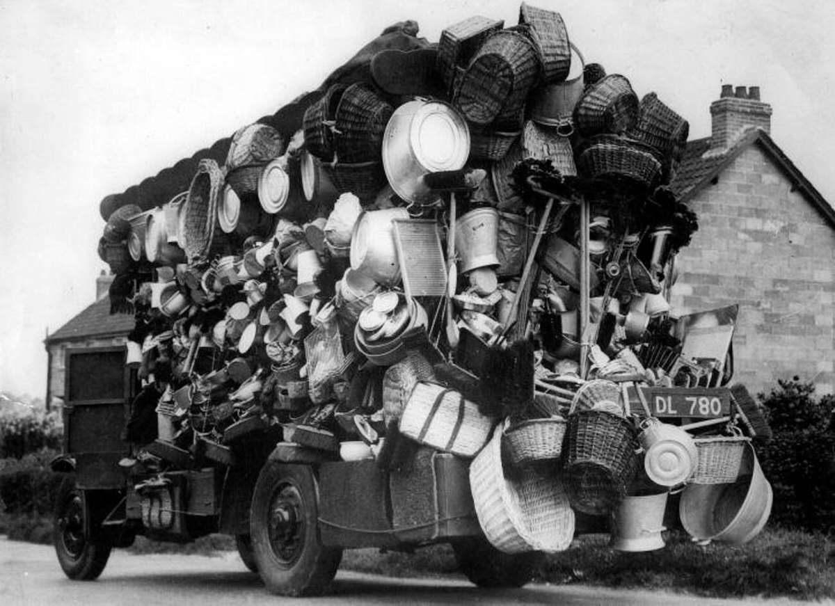 Overloaded car of a motorized peddler with household items, 1930s