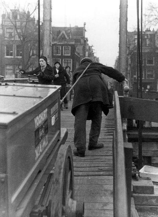 Human draught-horse. Man dragging carts over a steep bridge, for a small fee. Amsterdam, The Netherlands, 1934.