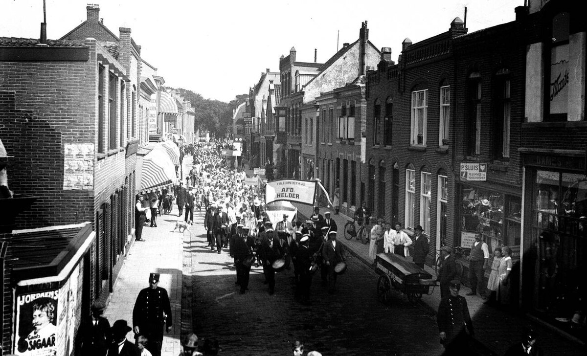 Parade with a music corps and school children between Keizersbrug and the city center, 1930