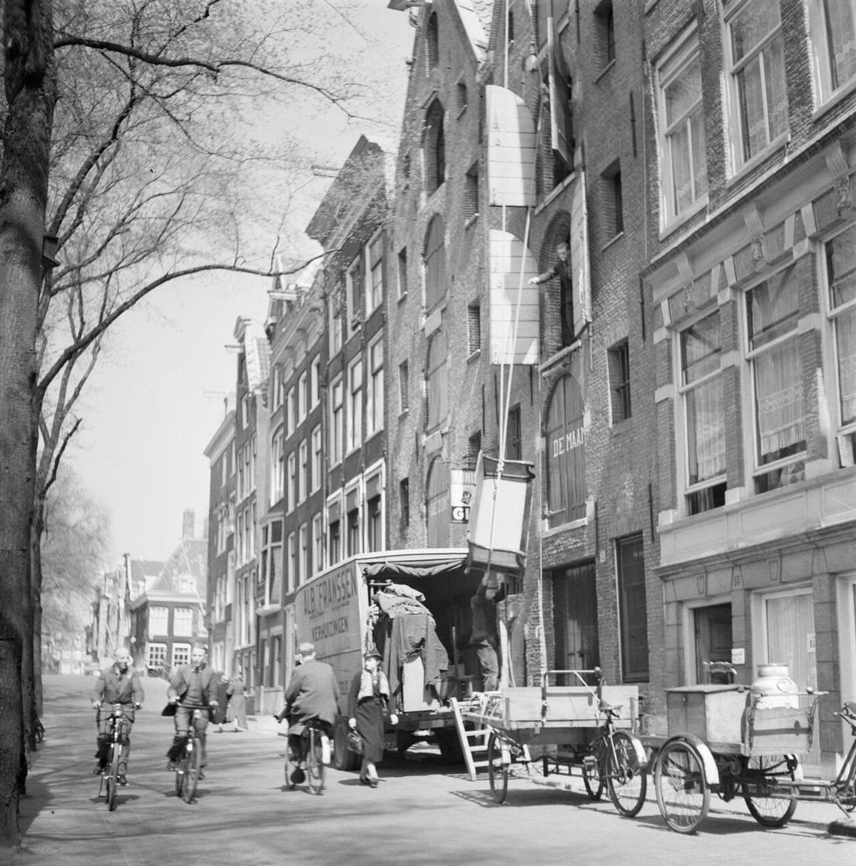Men loading a moving van at an apartment building, 1932