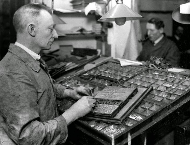 Type-setter composing a printing text with led letters.