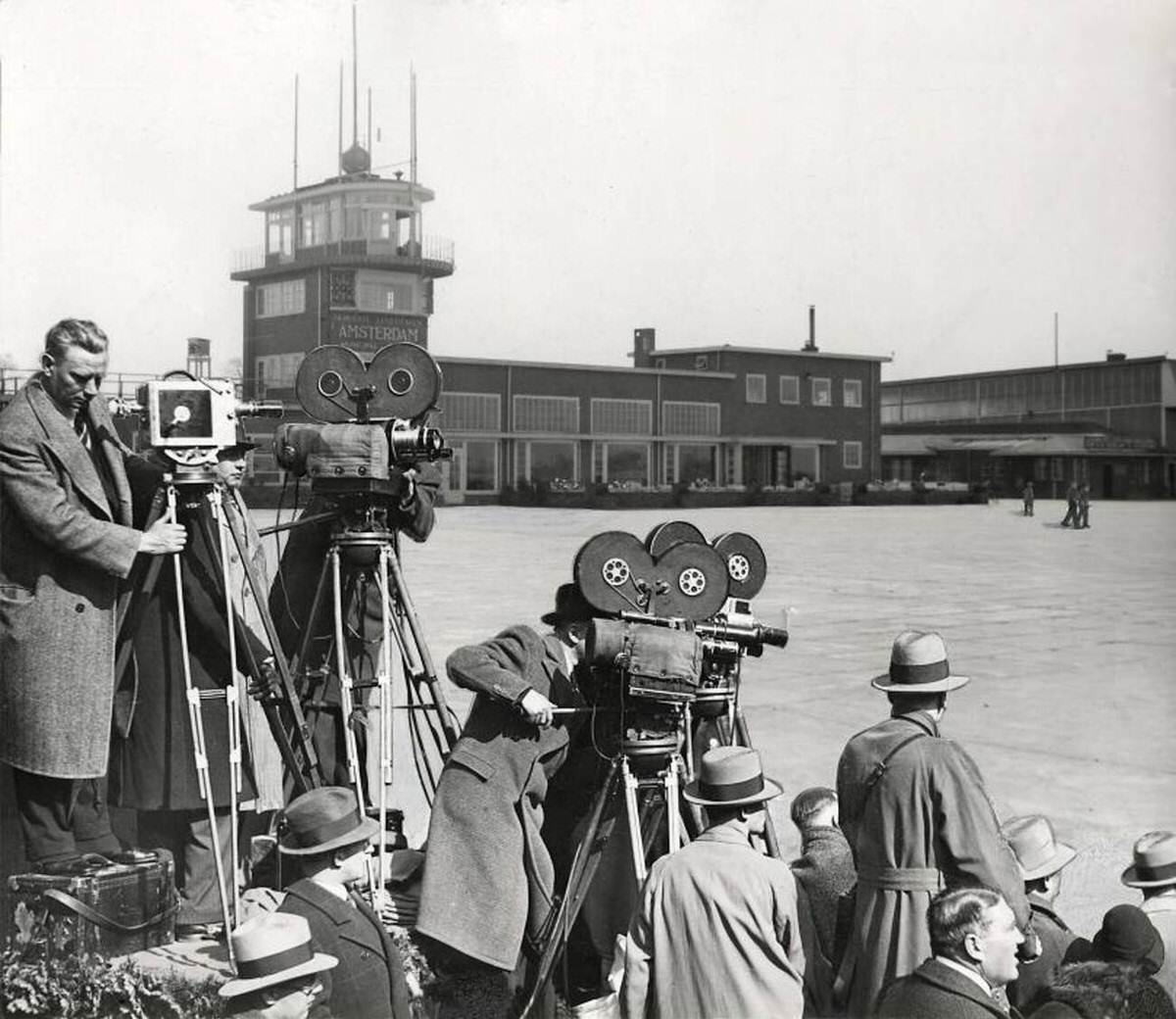 Film crew and photographers staging a fake article about a flying bicycle at Schiphol Airport, 1933