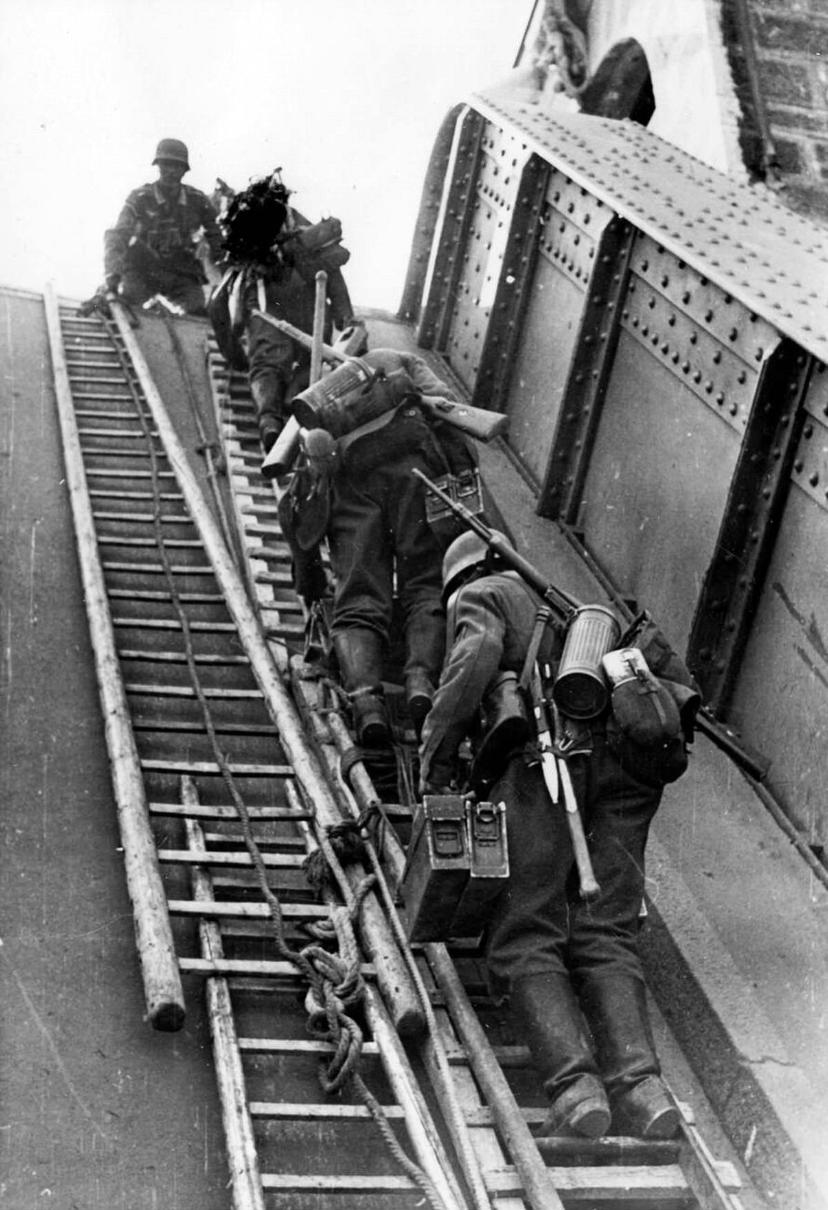German Wehrmacht soldiers crossing a destroyed bridge on ladders, 1940