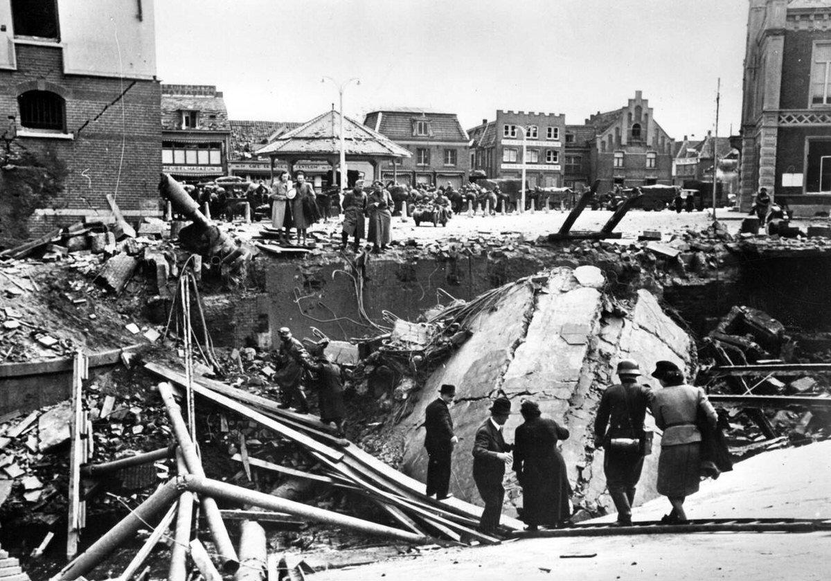 German soldiers helping civilians cross a bridge blown up by the Dutch, 1940