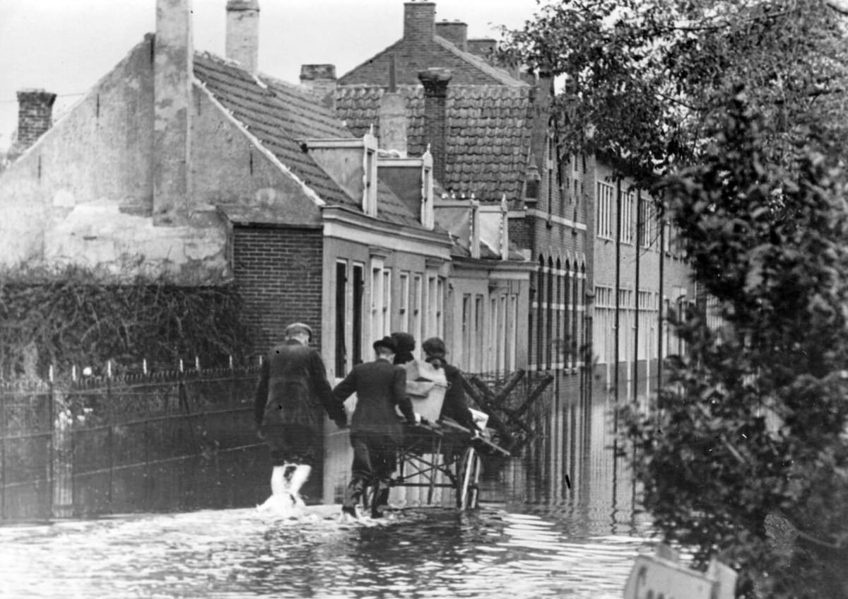 Locals carrying belongings through a flooded town on the Walcheren peninsula, 1944