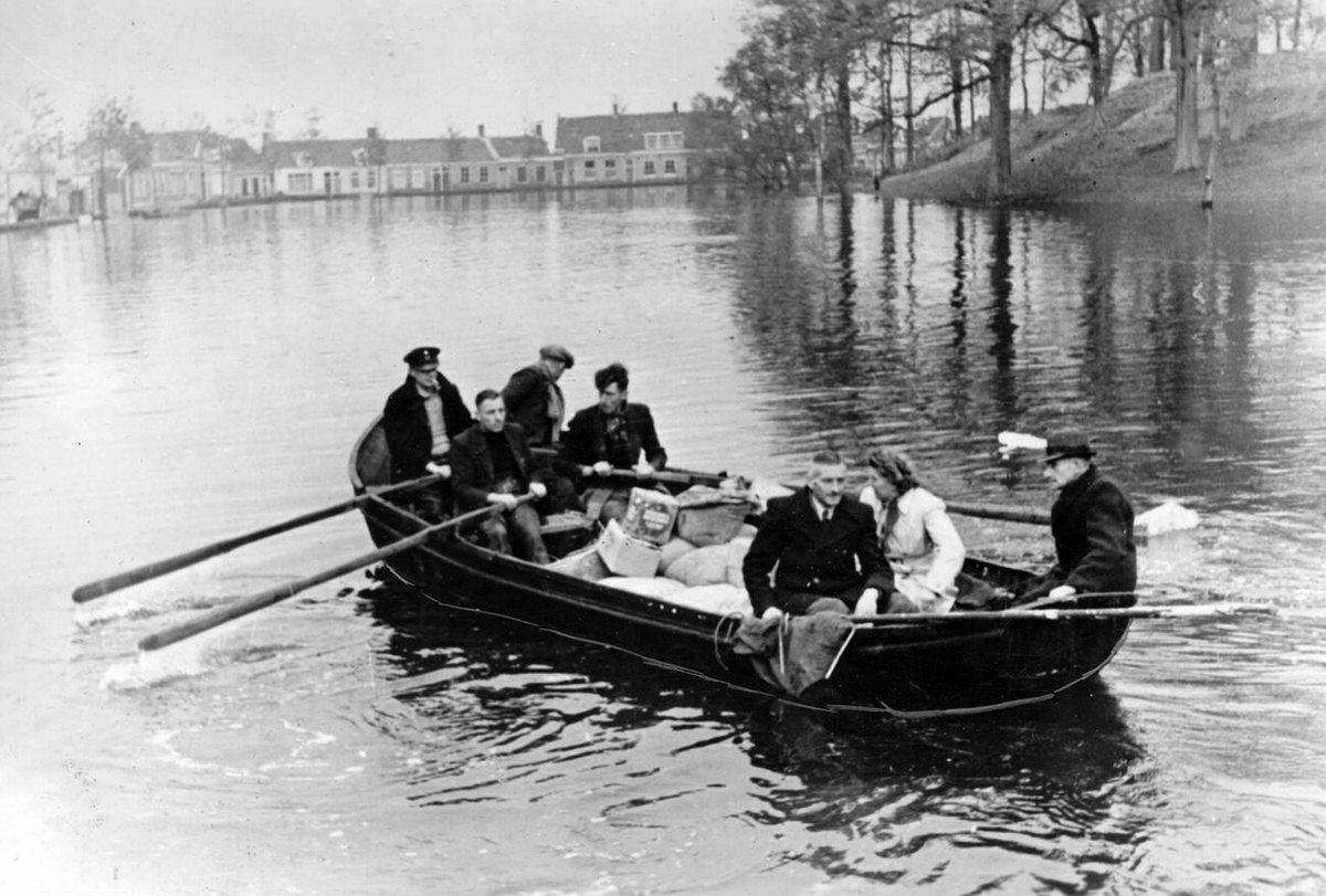 Locals in a boat crossing a flooded square on the Walcheren peninsula, 1944