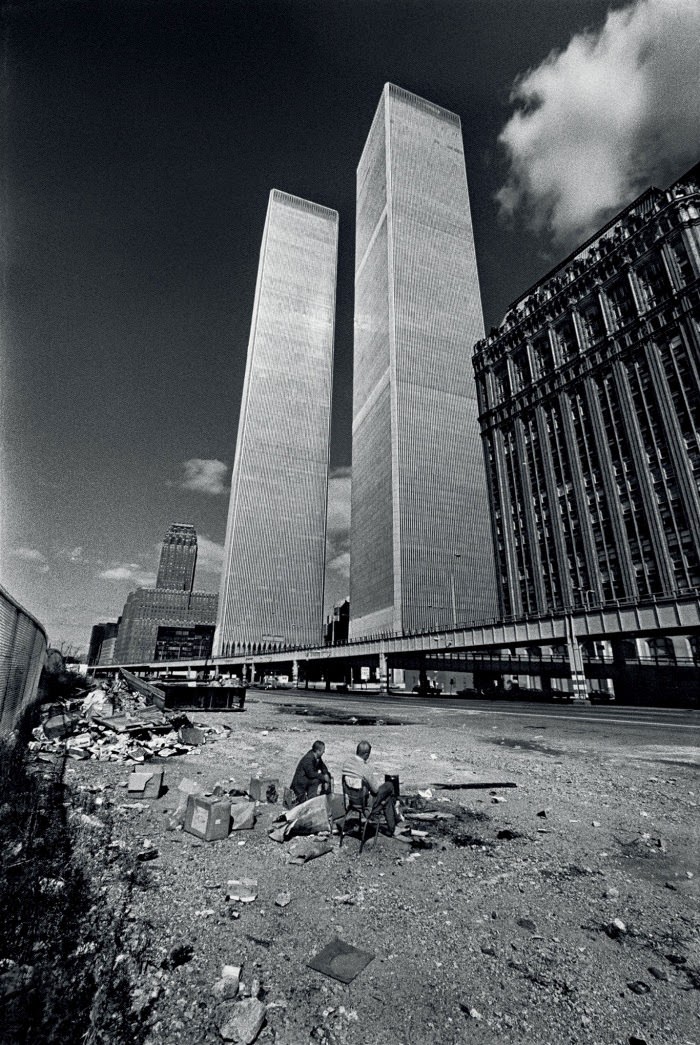 Two homeless men squat in the shadow of the recently completed World Trade Center in October, 1975. New York City was on the verge of bankruptcy and the World Trade Center sat largely vacant.