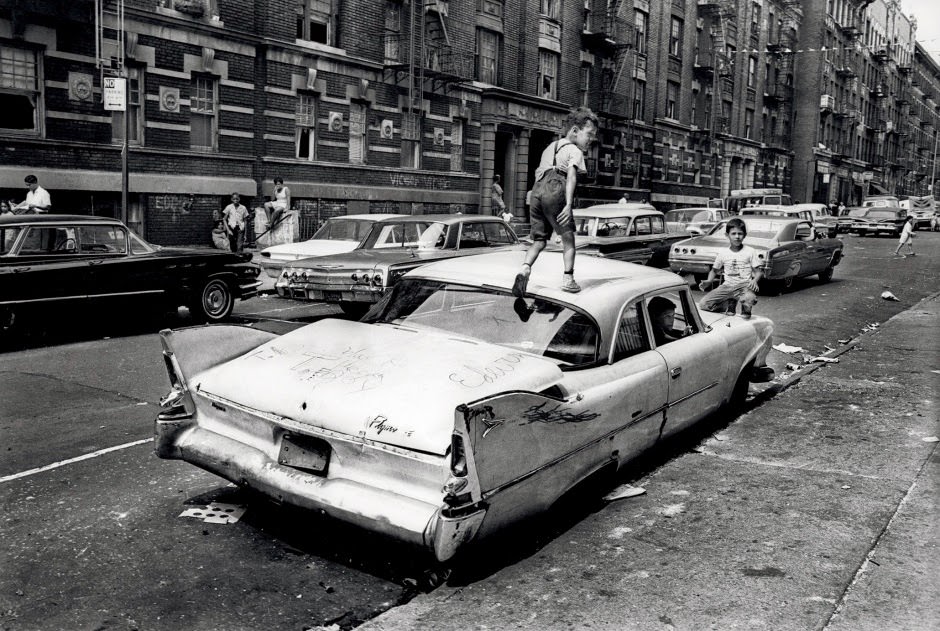 On Fox Street in the Bronx, an abandoned Plymouth Savoy becomes a jungle gym for kids to play on in the summer of 1966.