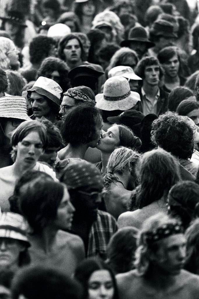 A young couple kisses as the chaos of the crowd whirs around them with an estimated 600,000 rock fans on July 28, 1973. The Summer Jam at Watkins Glen was a 1973 rock festival which once received the Guinness Book of World Records entry for “Largest audience at a pop festival.”