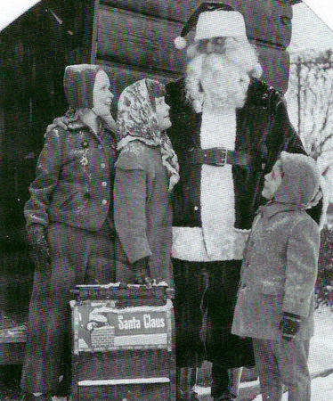 Santa Claus and children at a special holiday mailbox in Cameron Field, South Orange, 1940s
