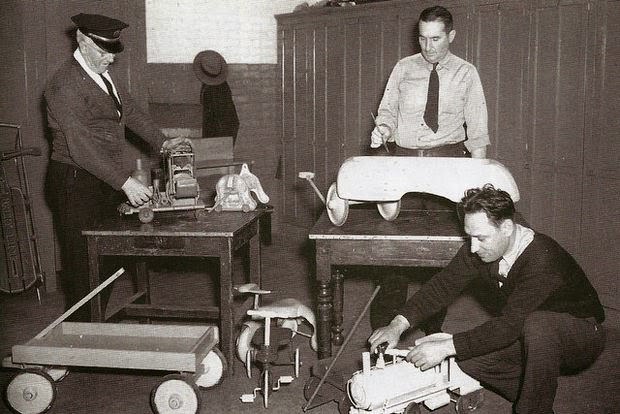 Firemen repairing toys for needy children in Montclair, 1950s