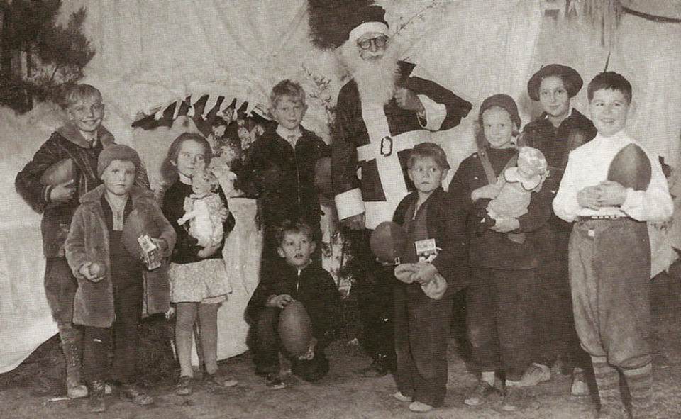 Santa Claus posing with children at the Laurelton School in Brick Township, 1930s
