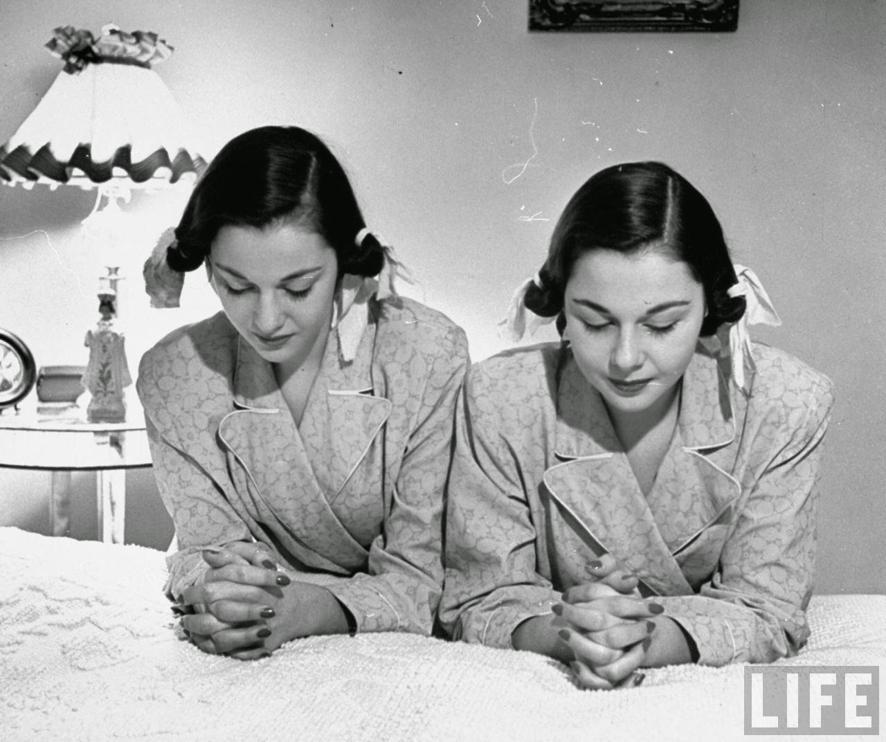 The O'Connor twins Gloria and Consuelo, praying before bed, almost exact look-alikes.