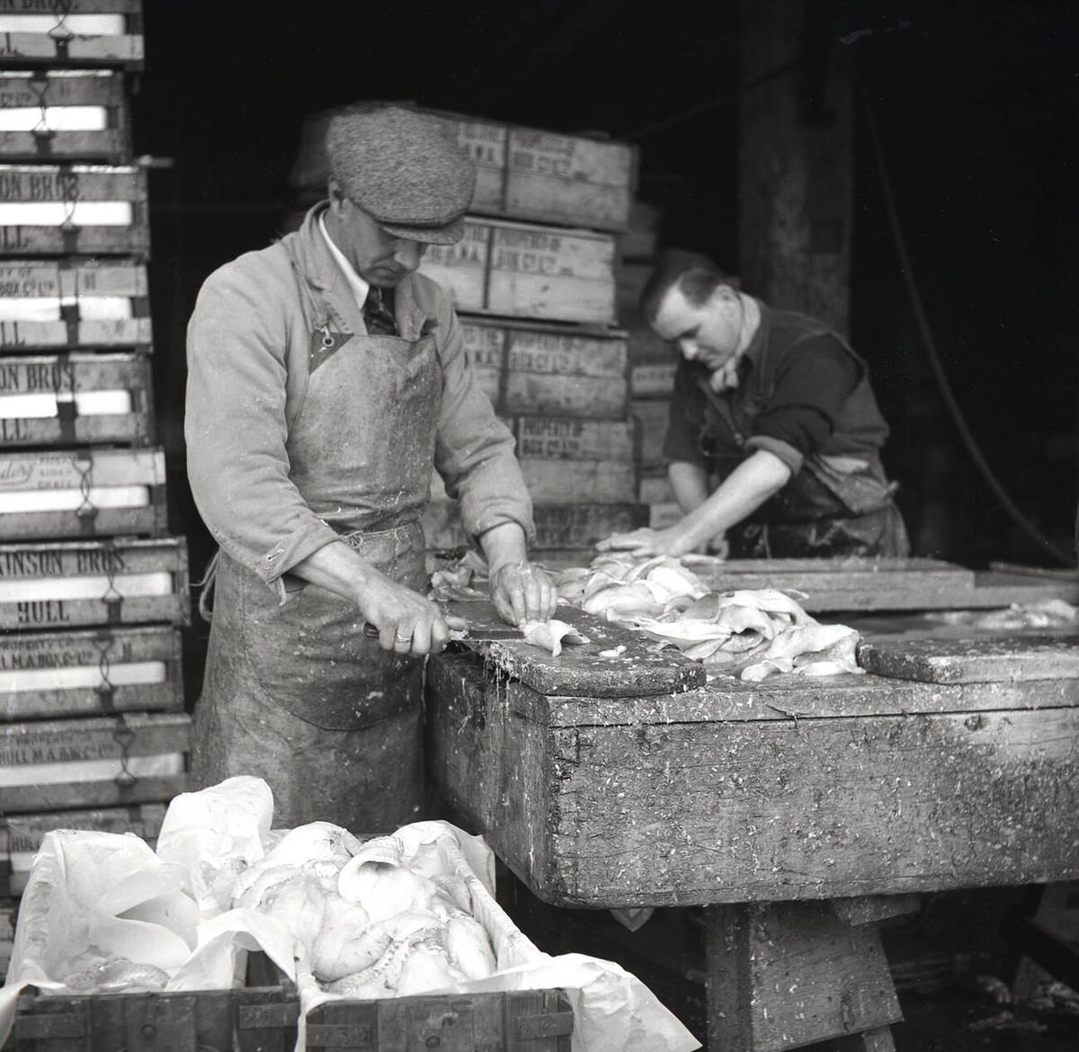 Workers filleting fresh fish outside Billingsgate Fish Market, 1950s