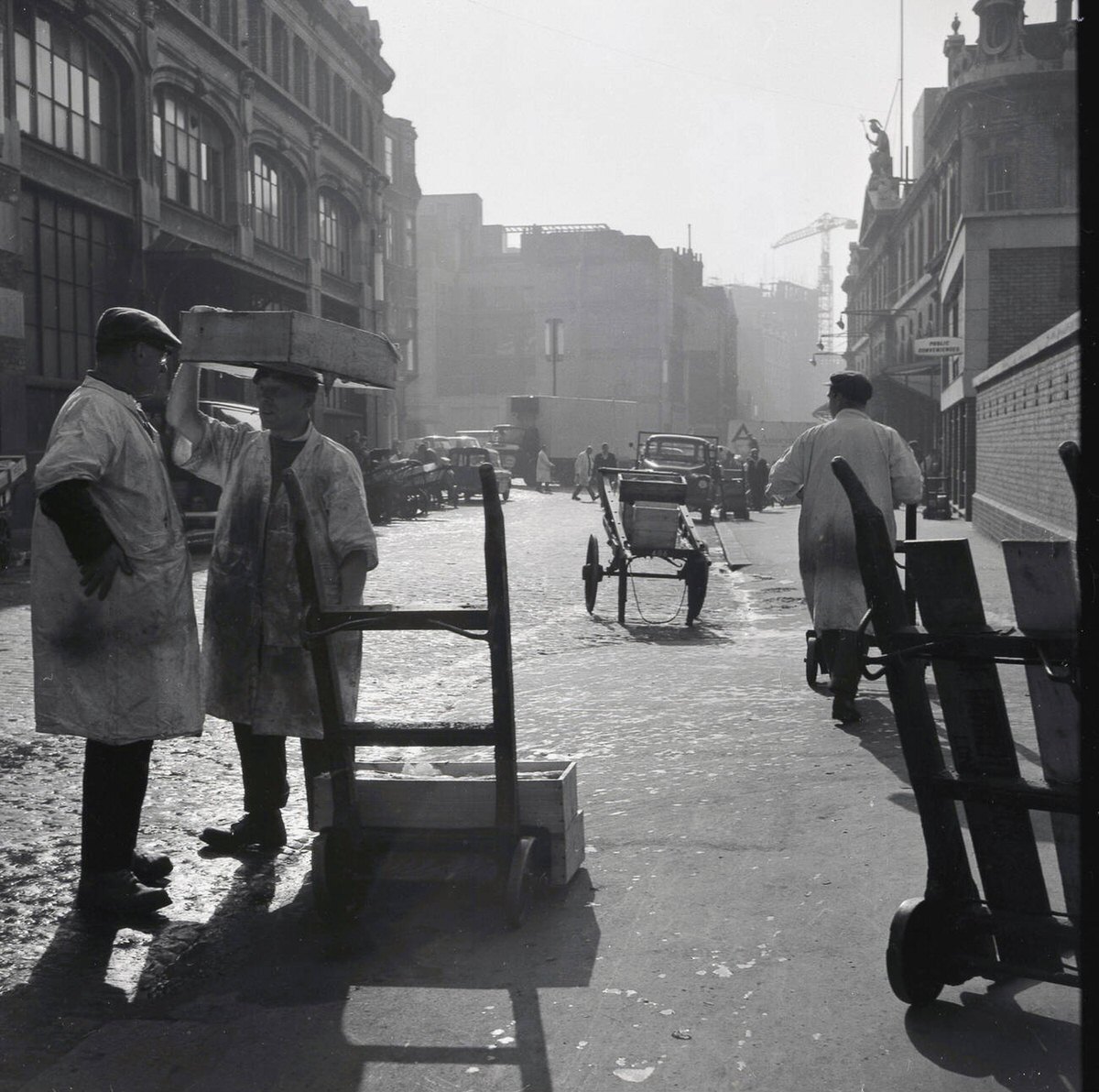 Porters and carts outside Billingsgate Fish Market on Lower Thames Street, 1950s