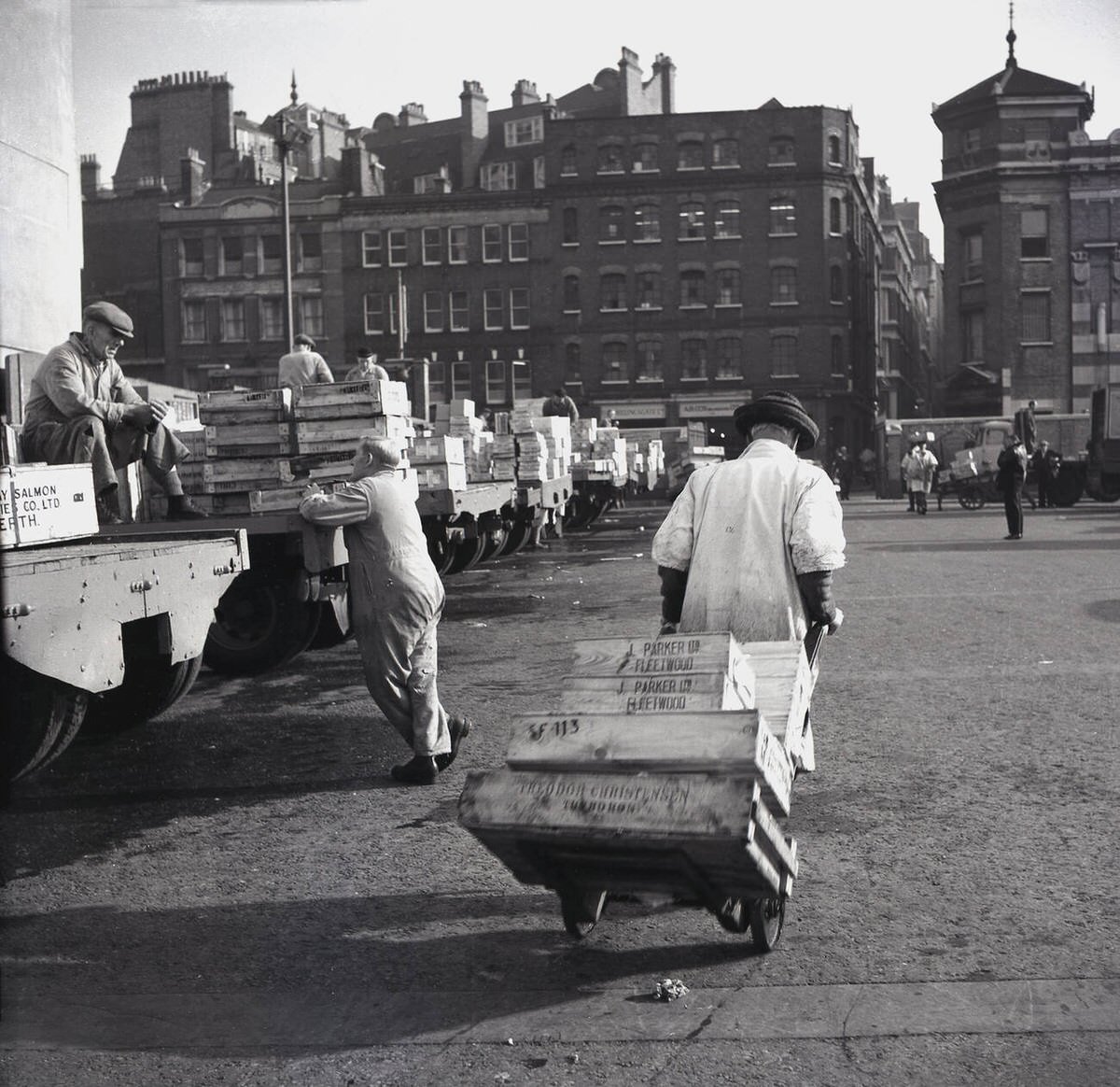 Porter pulling a barrow of crates from the lorry park at Billingsgate Fish Market, 1950s