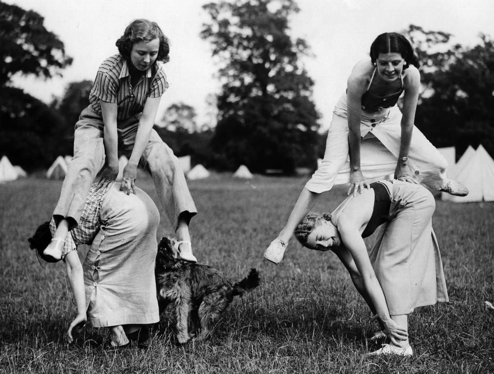 Campers playing leapfrog with their dog at Upshire, near Epping, 1936