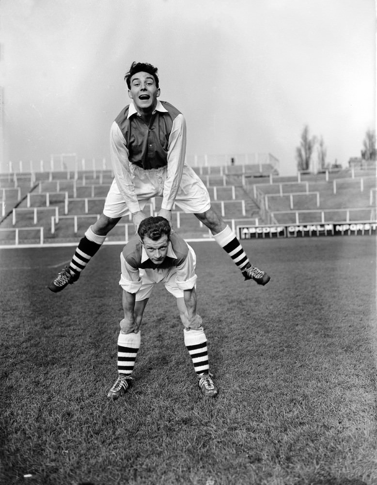Arsenal players Vic Groves and Stan Charlton playing leapfrog during training at Highbury Stadium, 1955