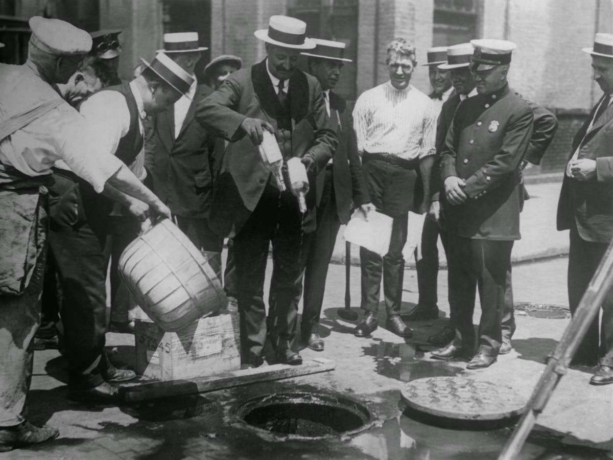 Prohibition began in 1920 with the passing of the Volstead Act. The Eighteenth Amendment of the United States Constitution, prohibiting the production and selling of "intoxicating liquors," had been ratified in 1919, and the Volstead Act was enacted in order to enforce and regulate the Amendment. Here, alcohol seized by police is dumped into sewage drains in New York.