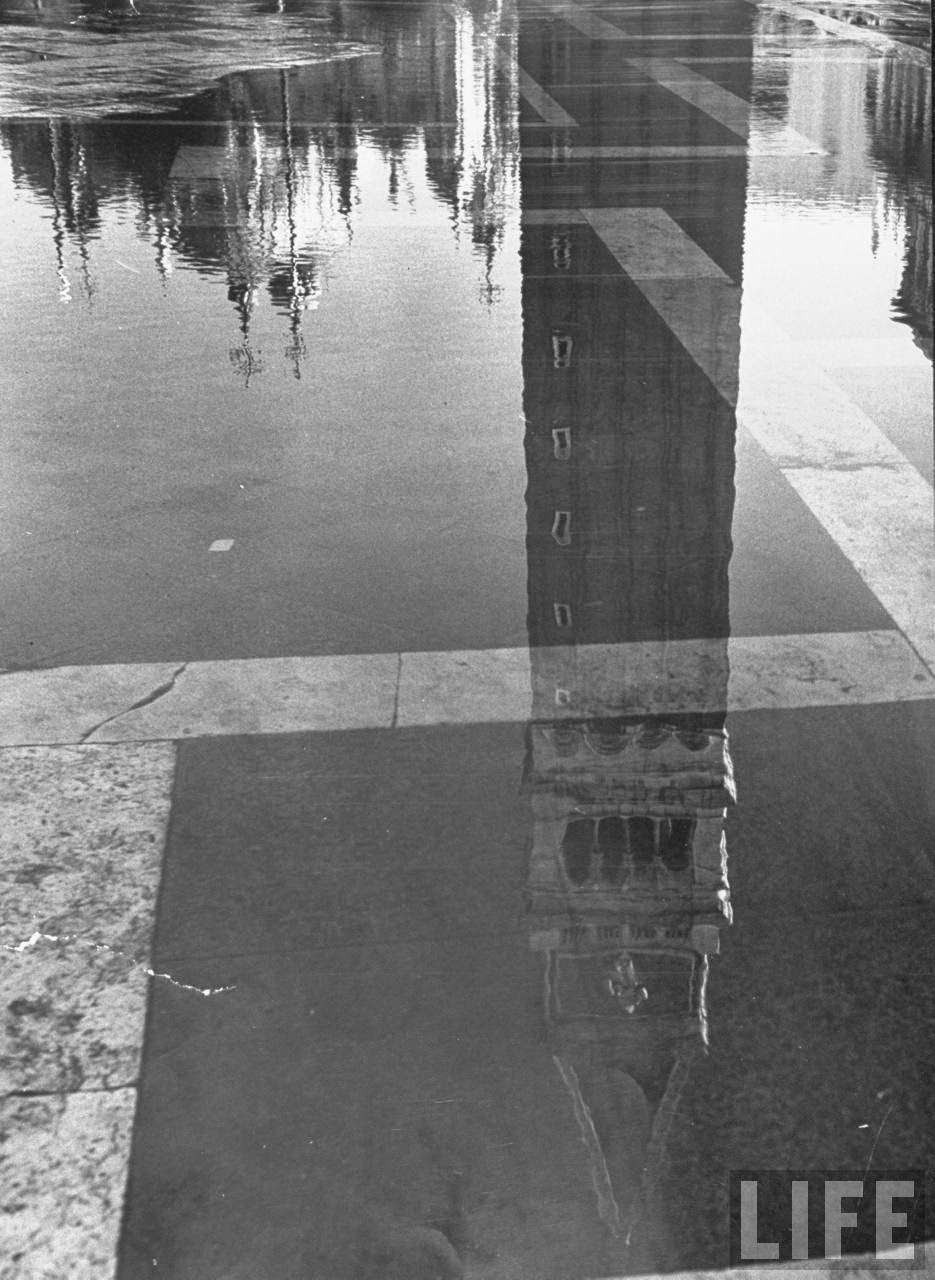 Upside down shimmering reflection of St. Mark's Basilica & tower playing off the flooded paved Piazza San Marco during it usual winter condition.