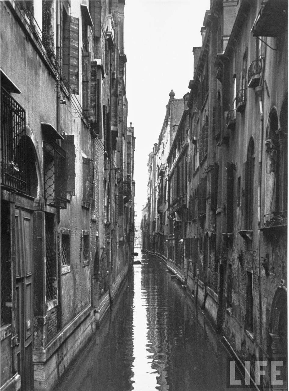 Narrow canal flowing between ancient buildings of the city.