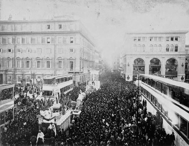 Carnival floats parade on Via del Corso near Piazza Colonna with Palazzo dei Magazzini Bocconi on the right, 1887
