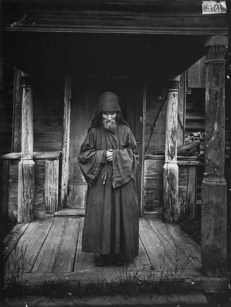 Portrait of an old priest in front of his house, 1900s