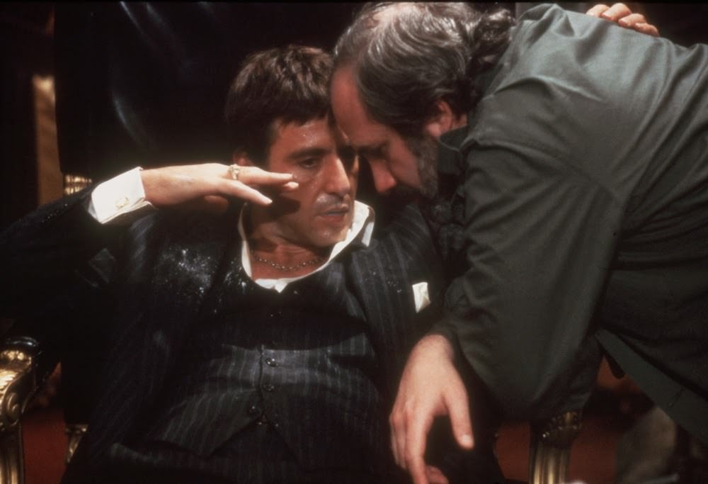 Al Pacino (as gangster Tony Montana) and director Brian De Palma have a tête-à-tête on the set of Scarface (1983).