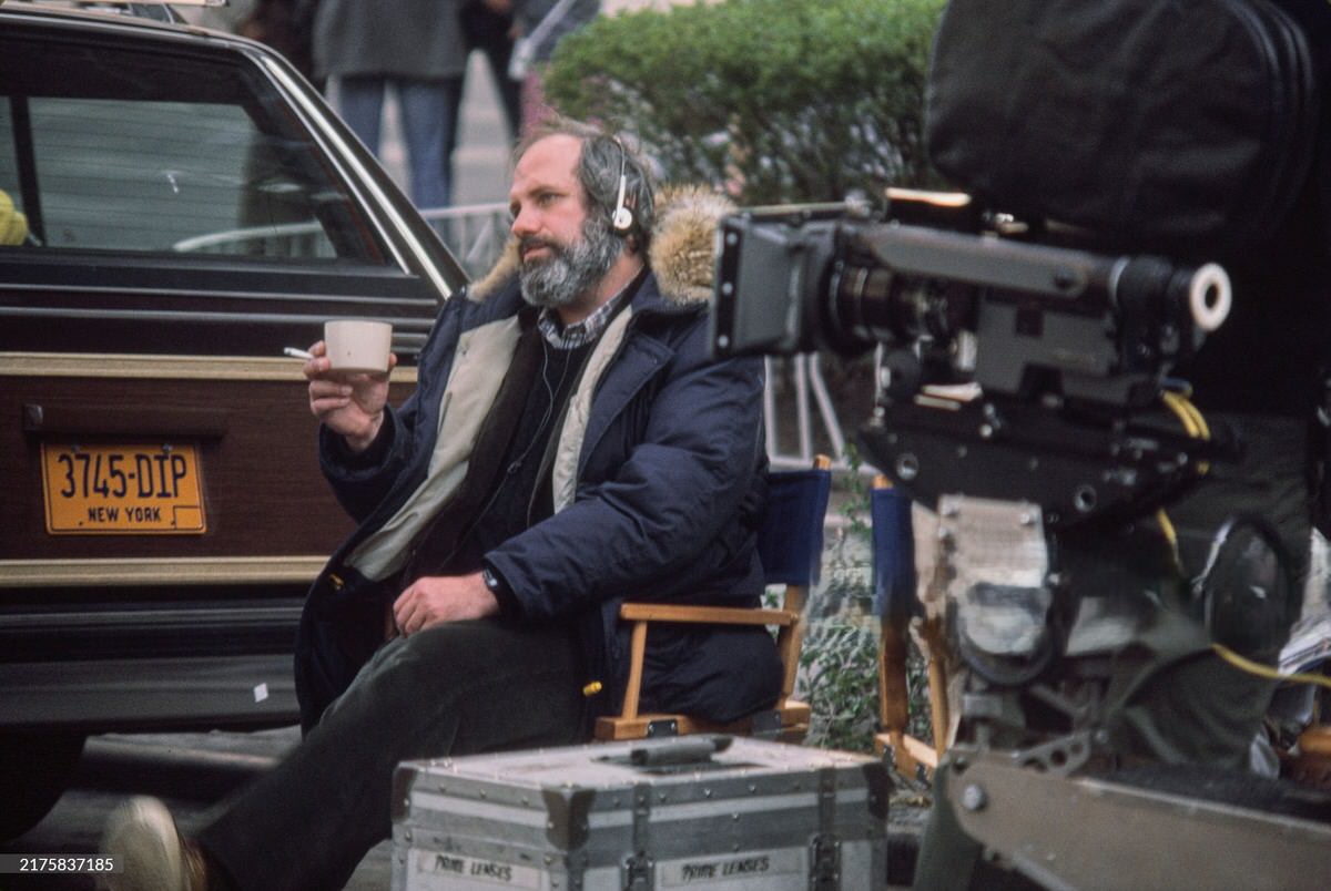 Brian De Palma wearing headphones during a break from filming on the set of 'Scarface' in Los Angeles, 1983