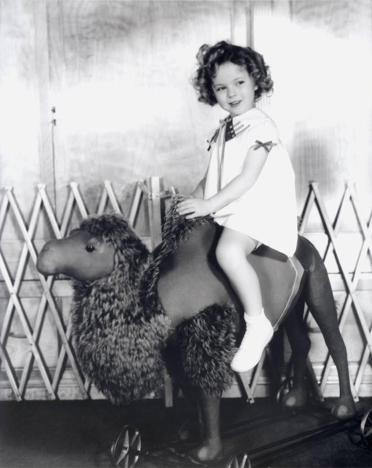 Shirley Temple on a giant camel toy, 1933