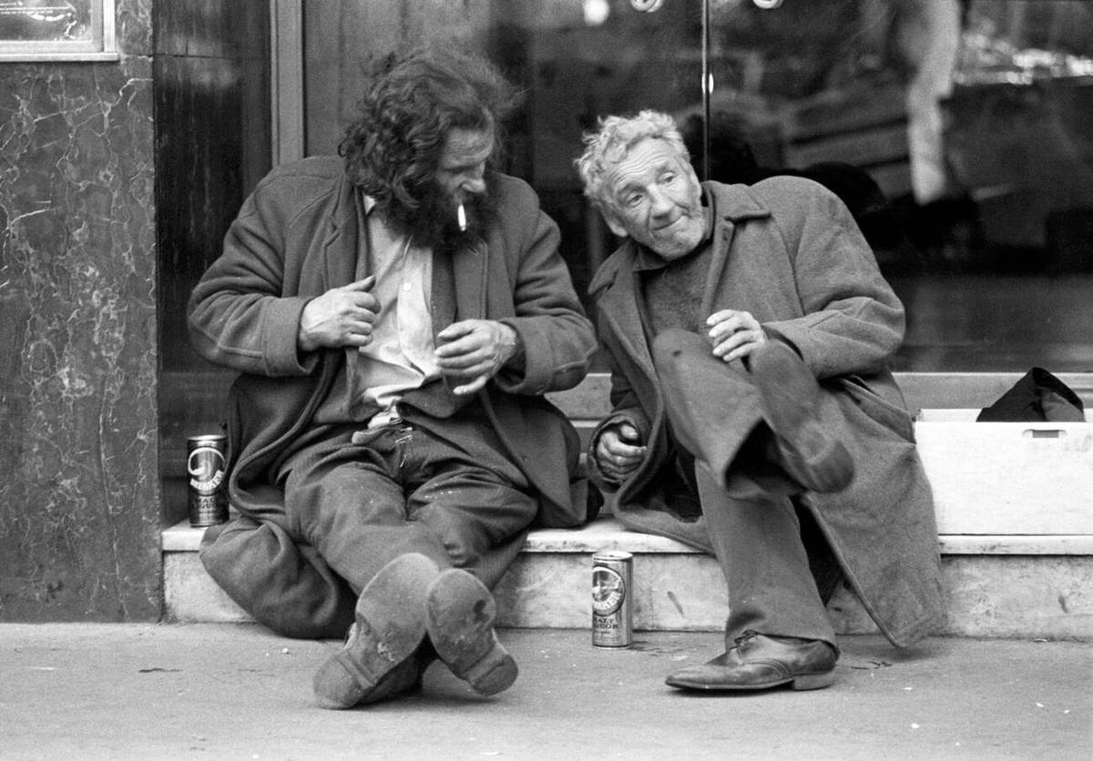 Two tramps chatting on restaurant steps in Soho, 1977