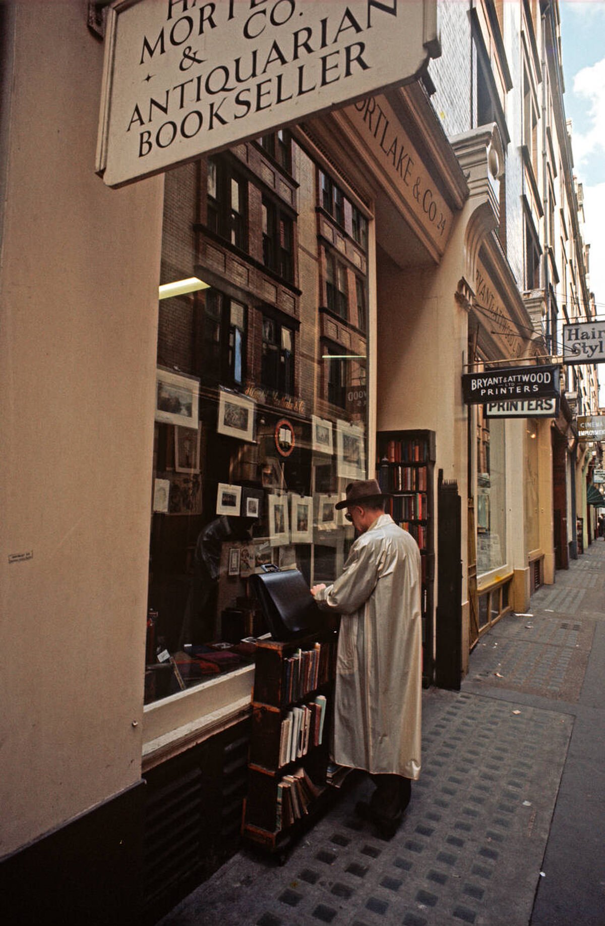 Man searching through books at an antiquarian bookshop in Soho, 1972