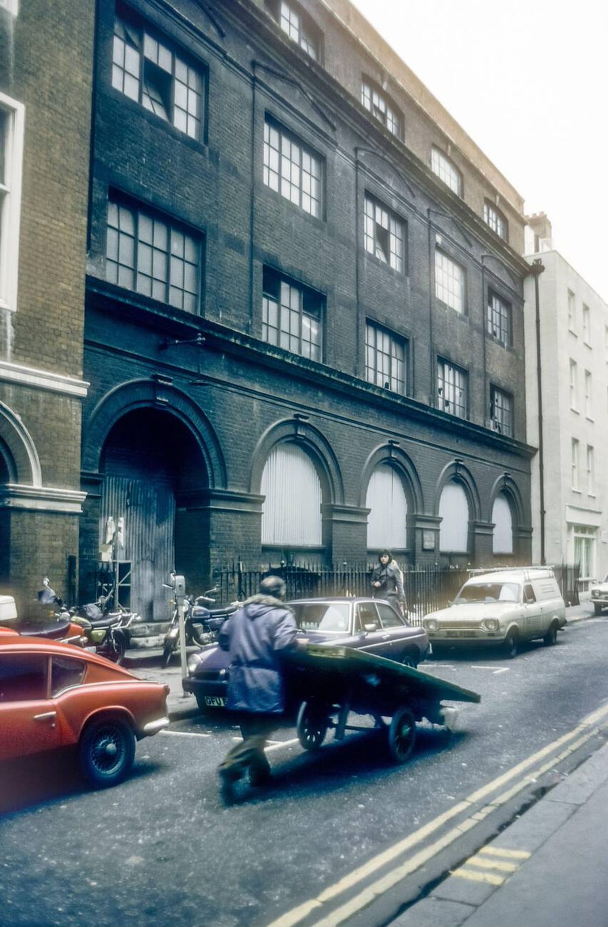 Man pushing a barrow in Soho, 1976