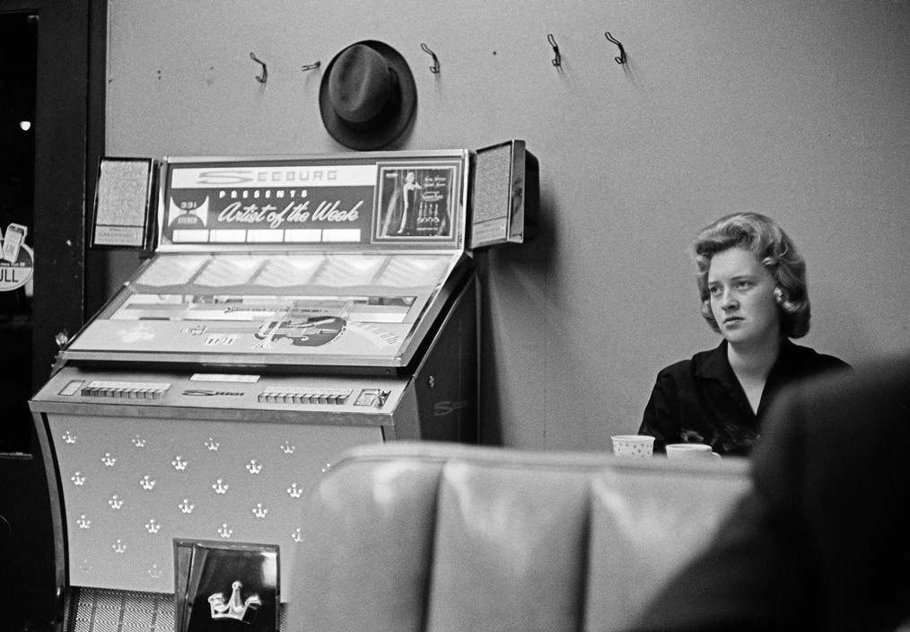 Woman in a diner with a jukebox, 1963
